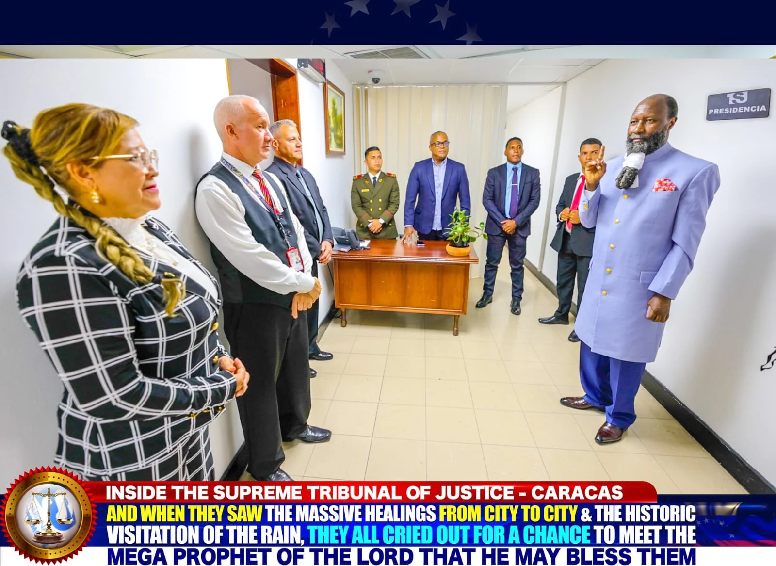 The Prophet addressing a row of officers of the Supreme Tribunal in a corridor marked Presidencia.