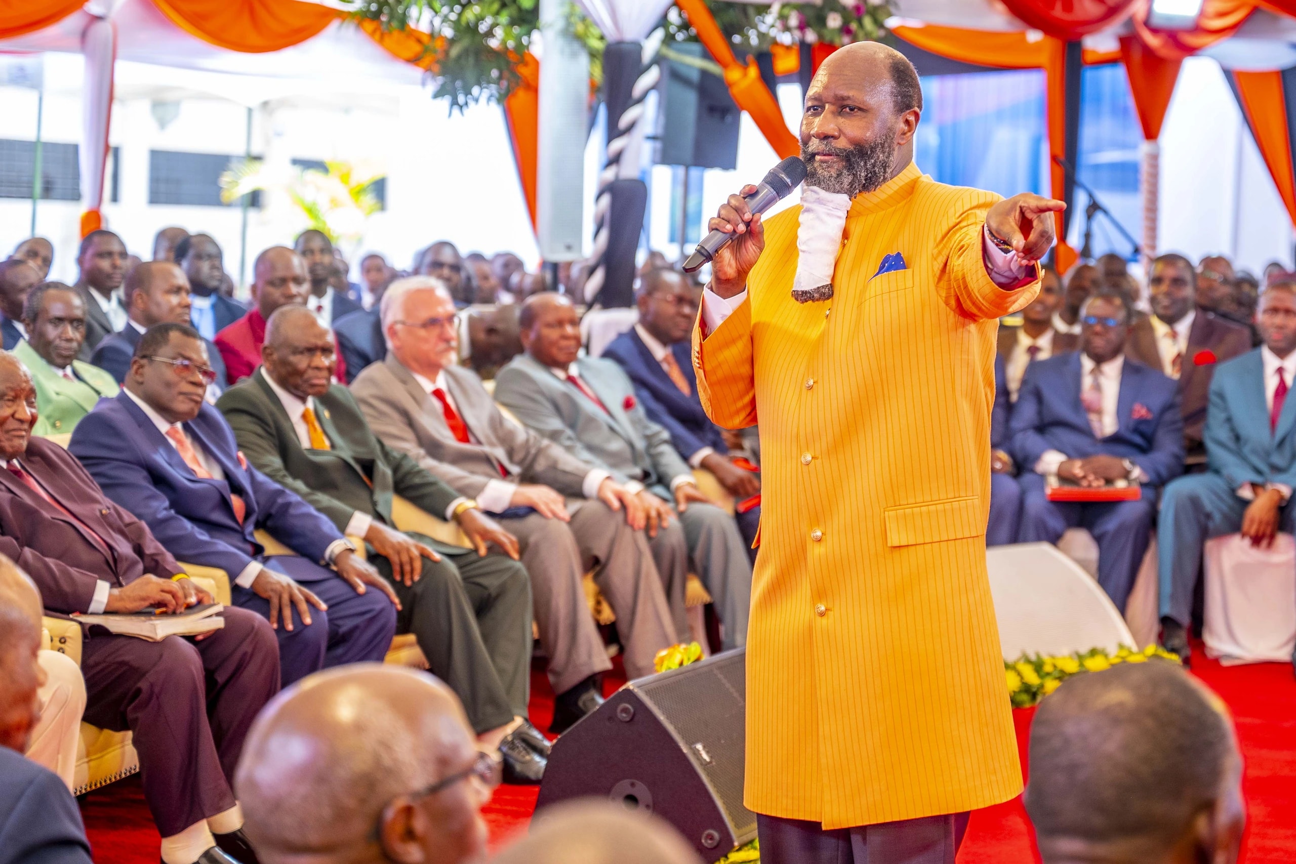 The preacher, in a yellow suit, pointing out over the seated delegates at the thanksgiving service after the Brazil mission.